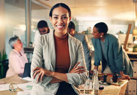 Face, business and woman with arms crossed, smile and career with teamwork, meeting or planning. Portrait, person or employee with cooperation, staff or professional with brainstorming in a workplace