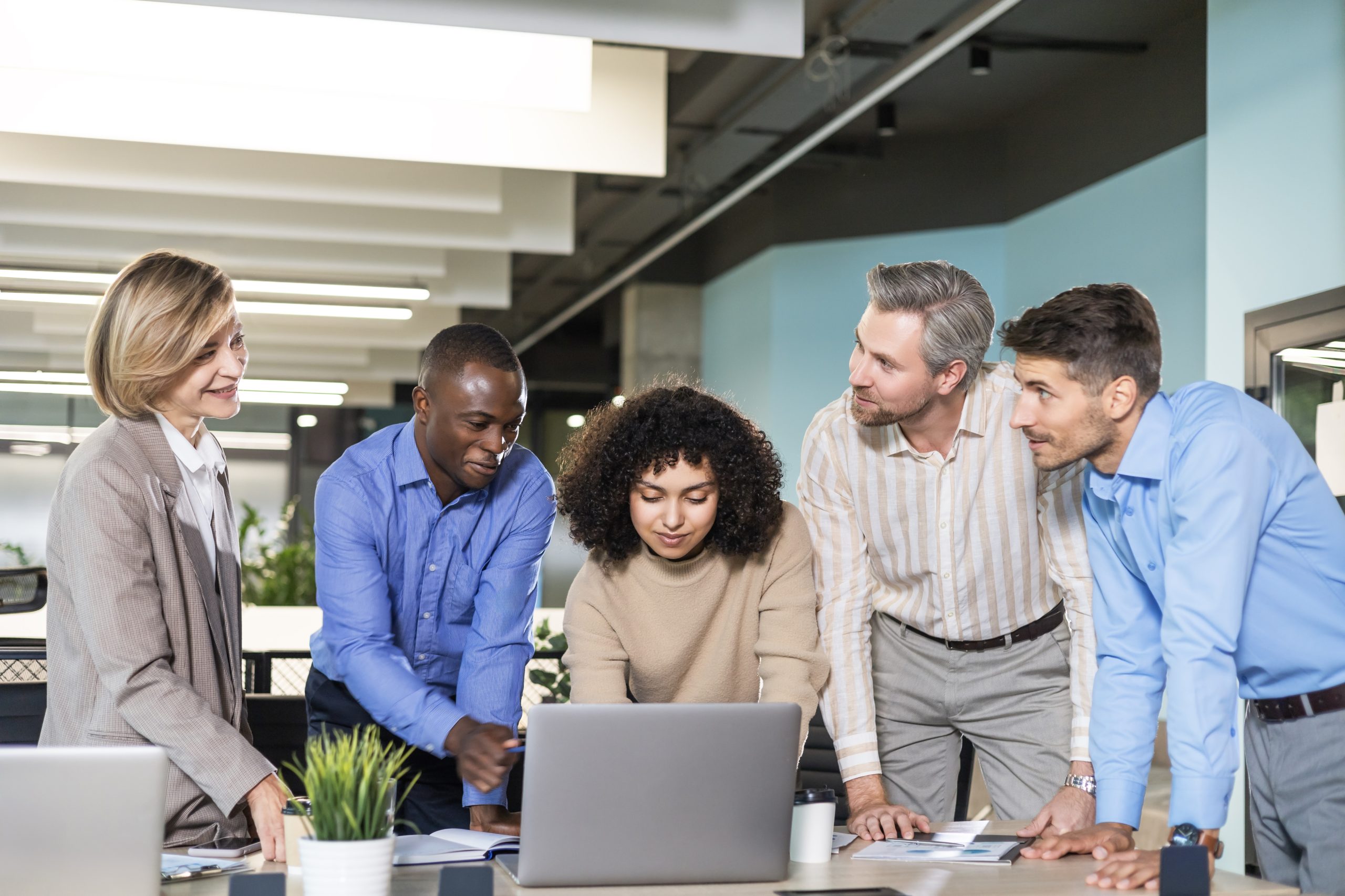 Group of young modern people using modern technologies while working in the creative office.